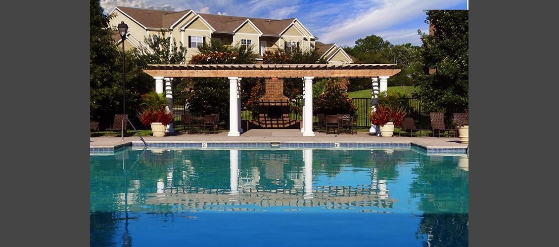 A large house with a swimming pool in front of it