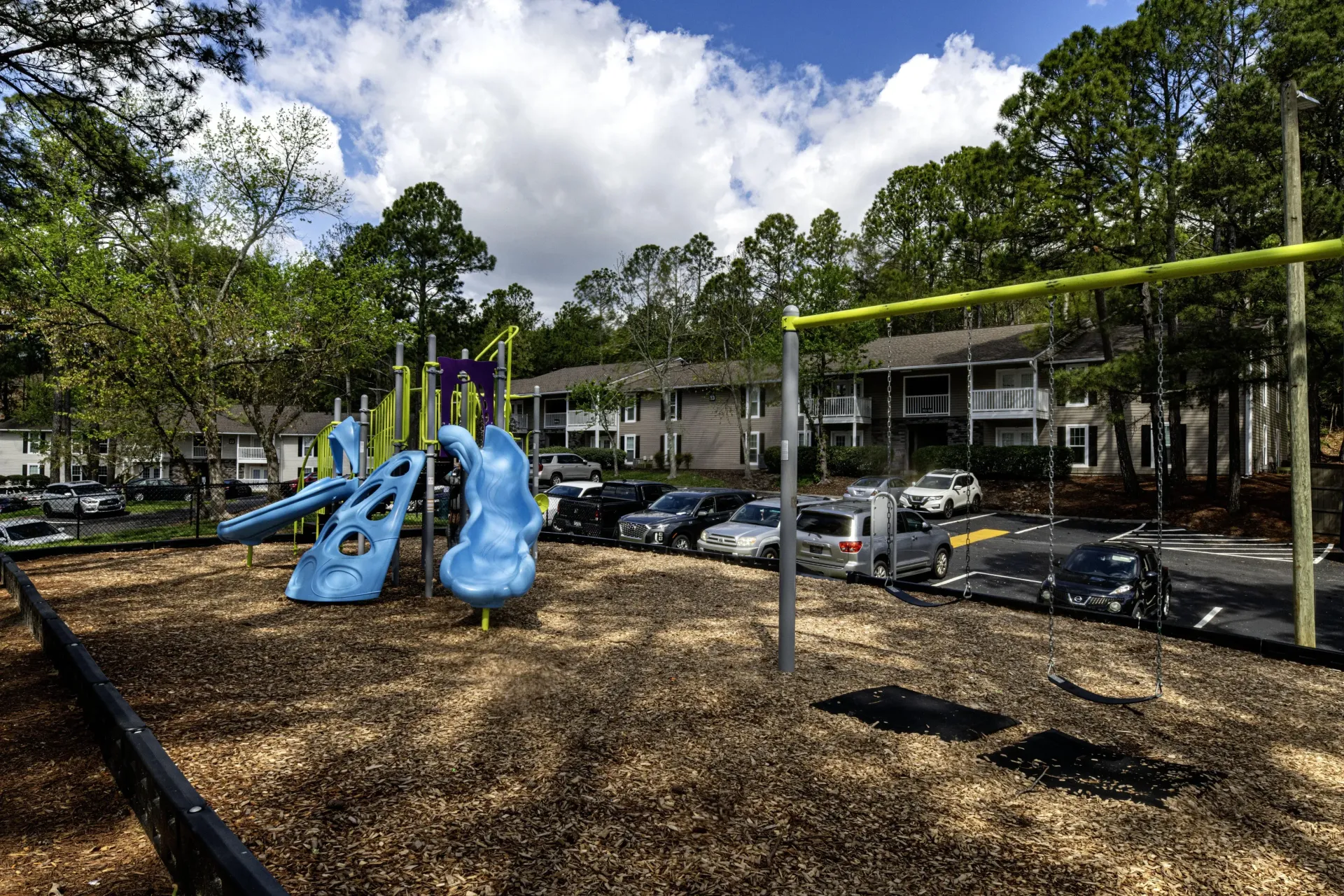 A playground with a slide and swings in a parking lot West Knoxville