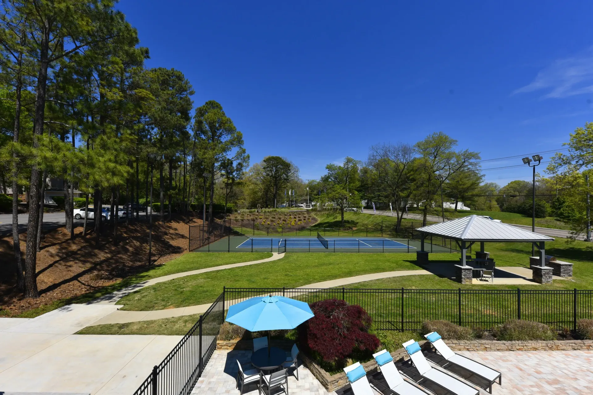 A large swimming pool surrounded by lawn chairs and umbrellas at a West Knoxville apartment