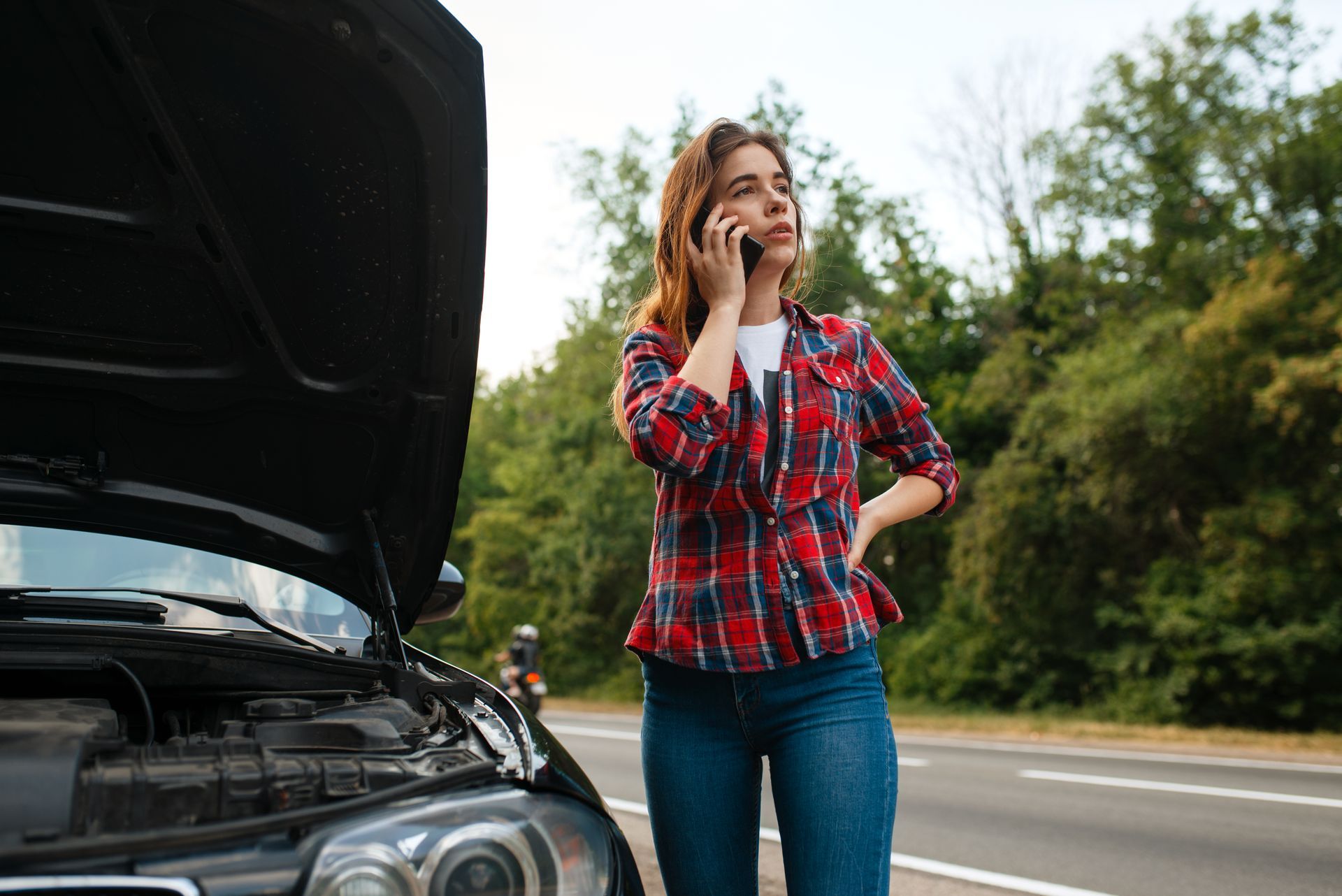 Woman calling a tow truck on road, car breakdown.