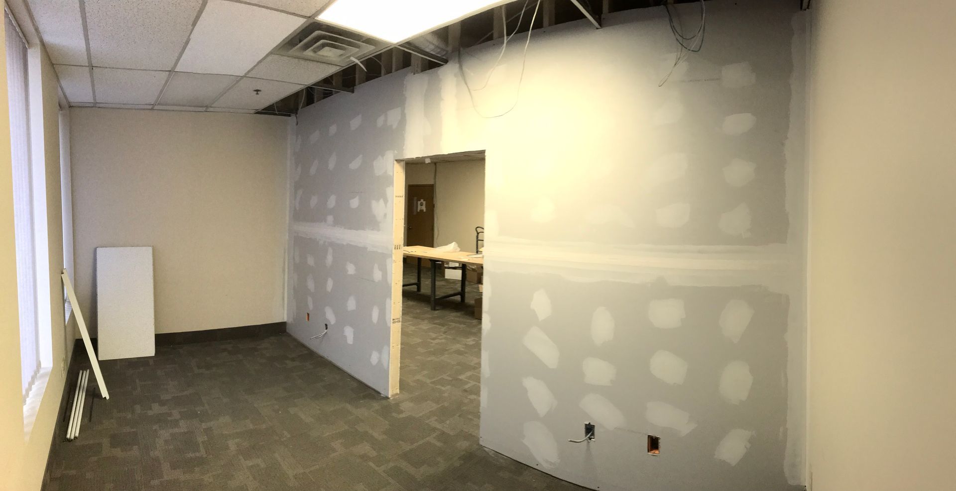 an empty room with drywall walls and a carpeted floor .