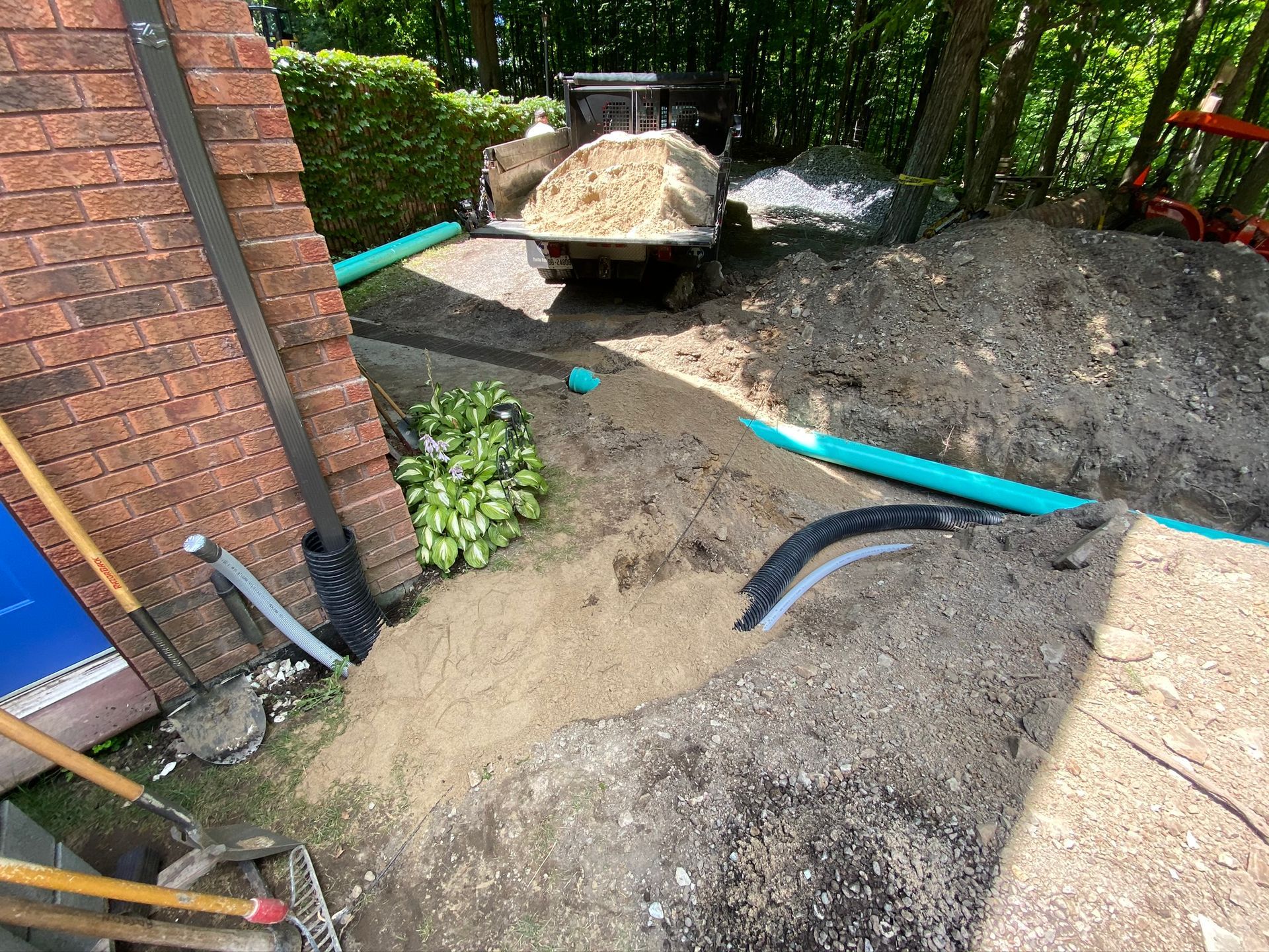 a wheelbarrow filled with dirt is sitting on top of a pile of dirt next to a brick building .
