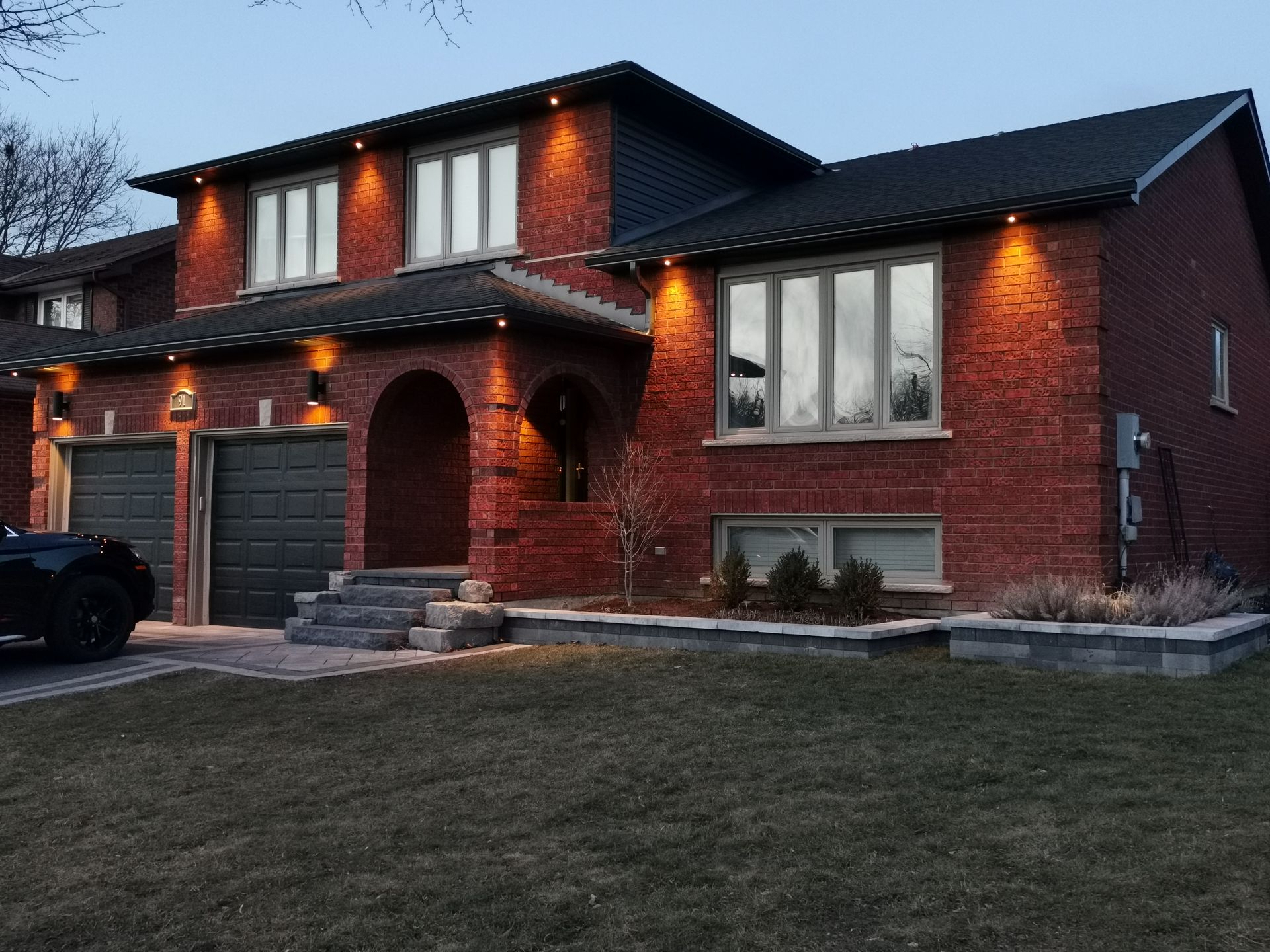 a large brick house with a black car parked in front of it