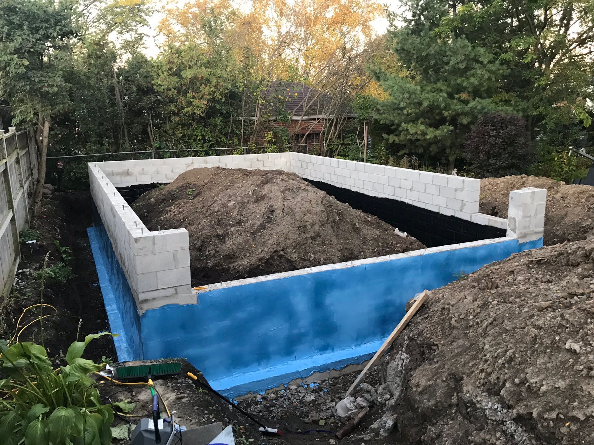 a foundation for a house is being built in a backyard .