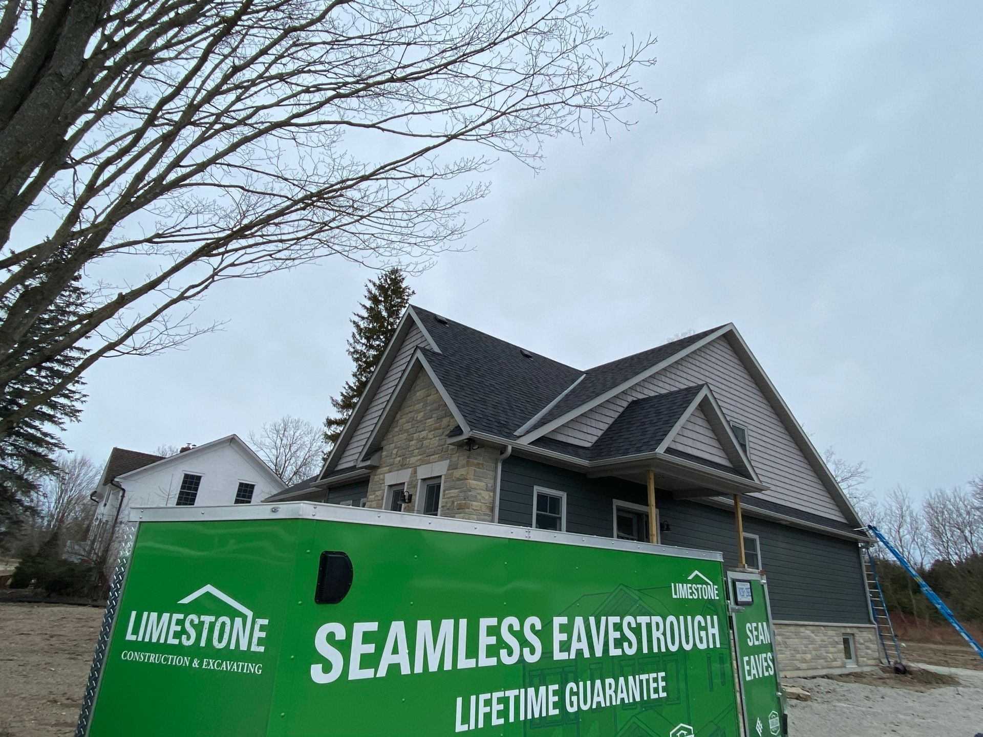 a green van is parked in front of a house under construction .