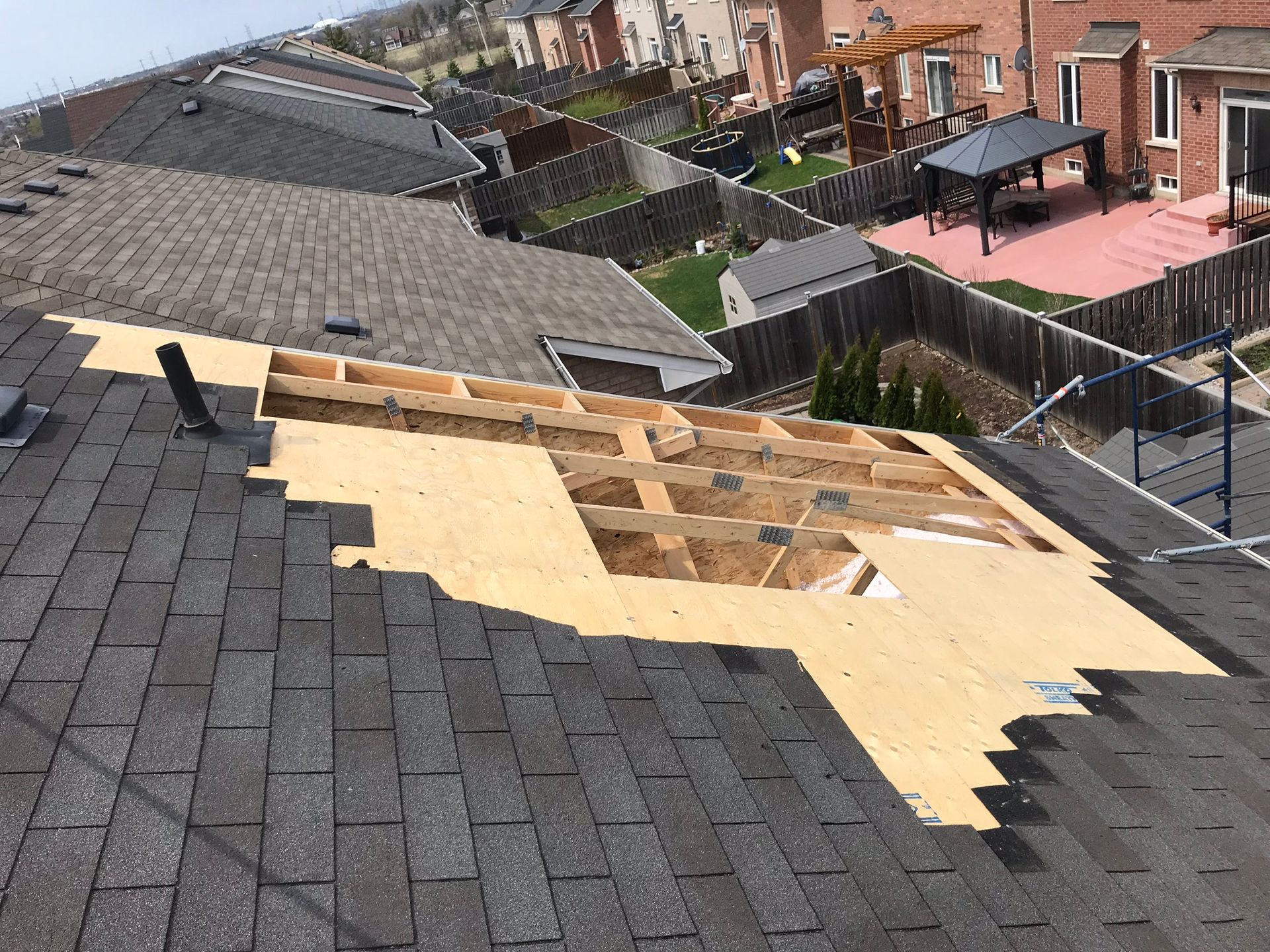 a roof is being repaired in a residential area .