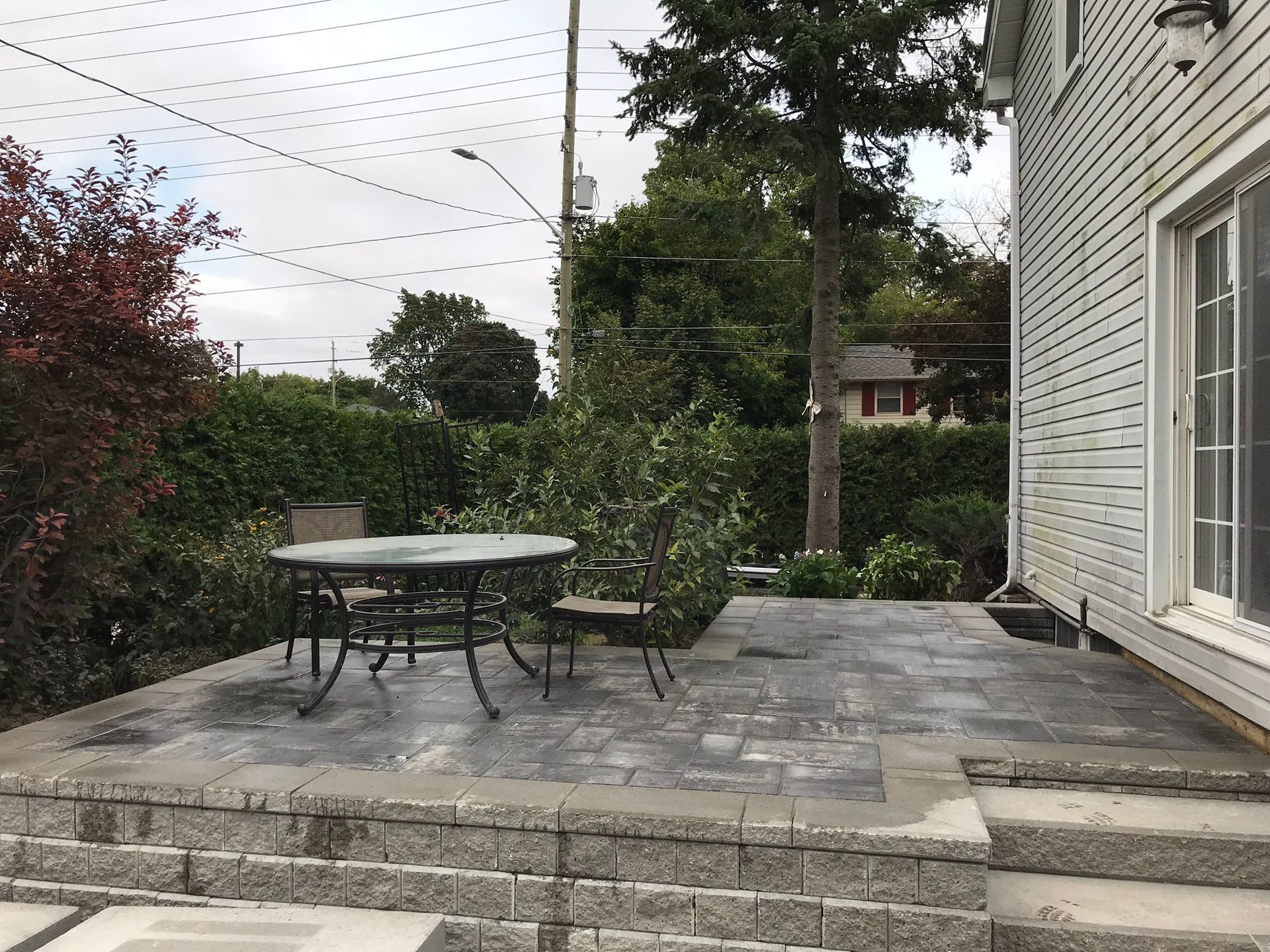 a patio with a table and chairs in front of a house .
