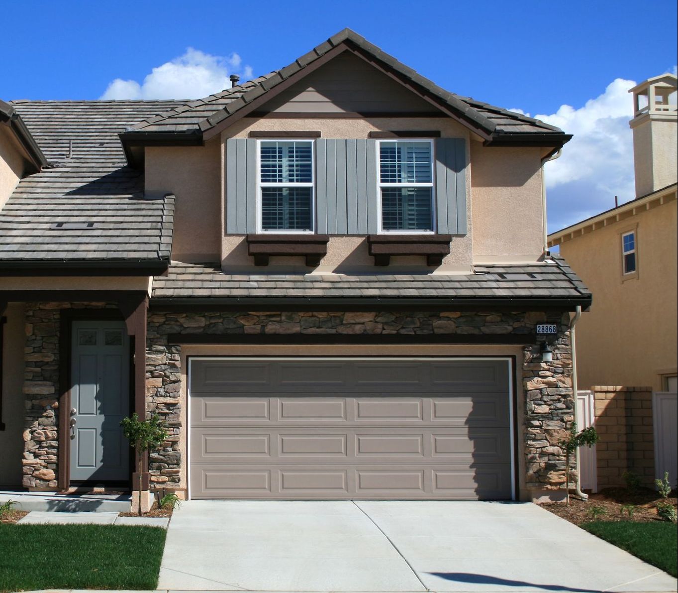 a house with a large garage and shutters on the windows