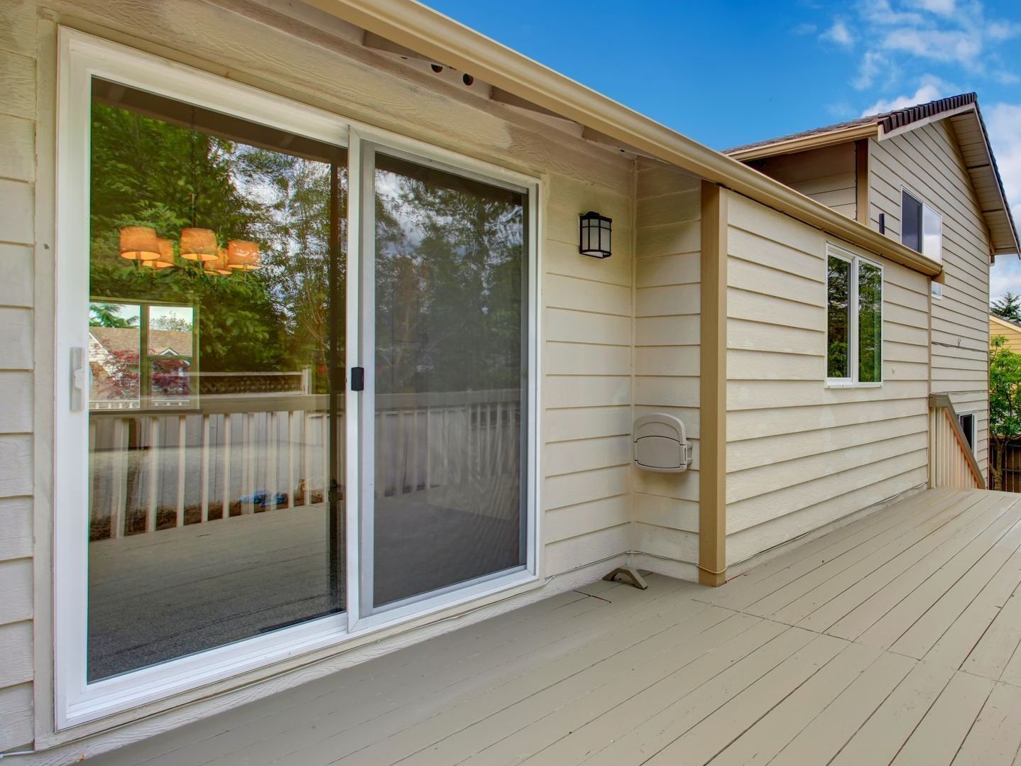 a house with a large deck and sliding glass doors .