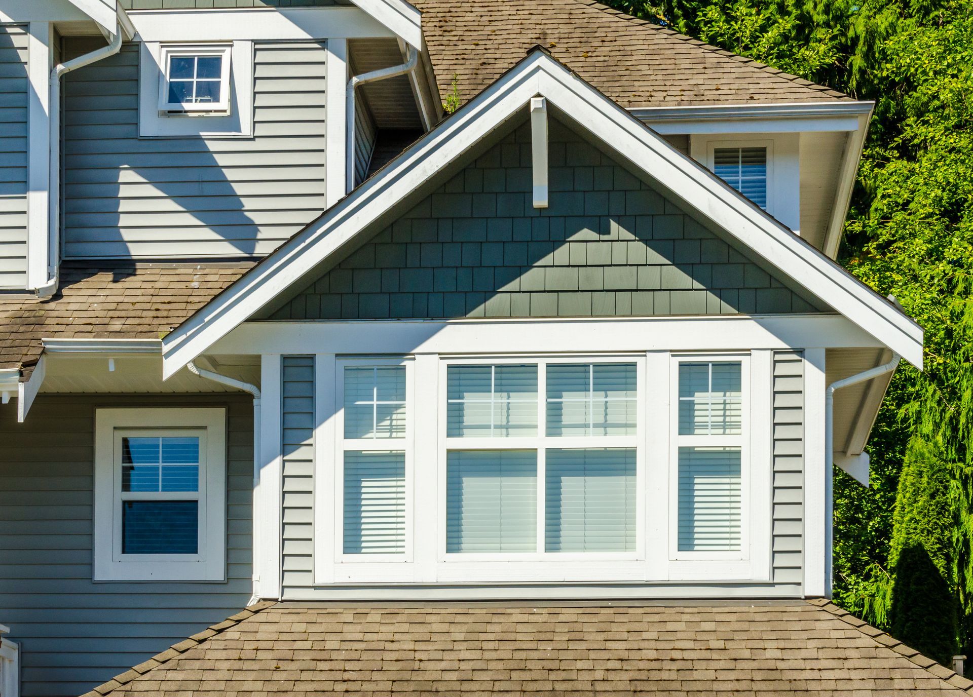 the roof of a house with a lot of windows and trees in the background .