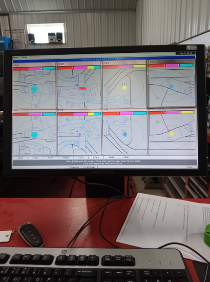 Desktop monitor showing a multi-panel map dashboard on a desk with a keyboard and papers nearby