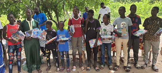 A group of people standing outdoors holding books and papers in a line.