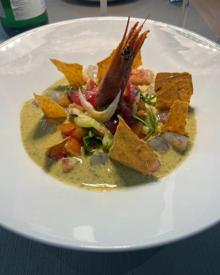 Apparecchiatura del tavolo del ristorante con sedie blu, tovaglia e carta da parati decorata.