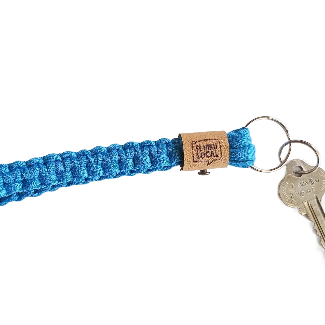 Blue woven lanyard with keys and a brown tag that reads "Te Voto Local."