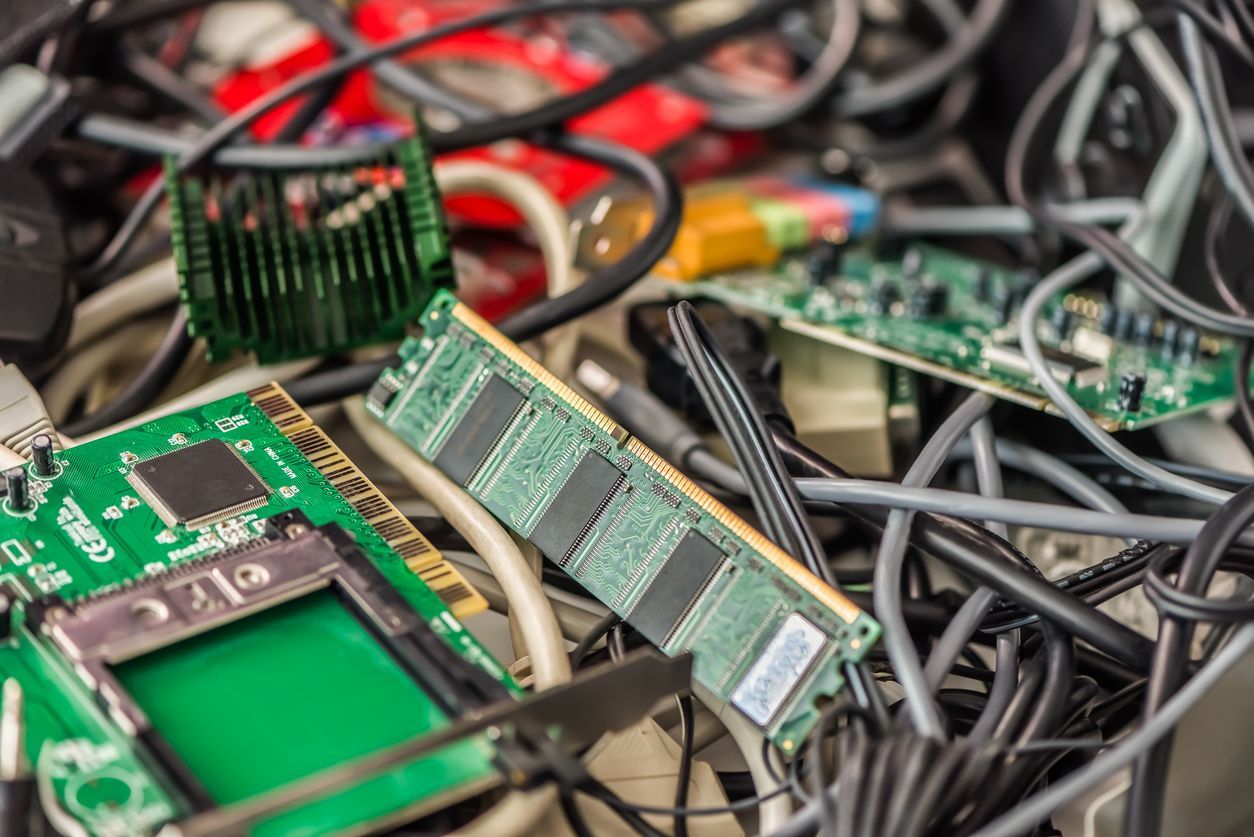 Pile of e-waste: circuit boards, RAM sticks, wires, and other electronic components.