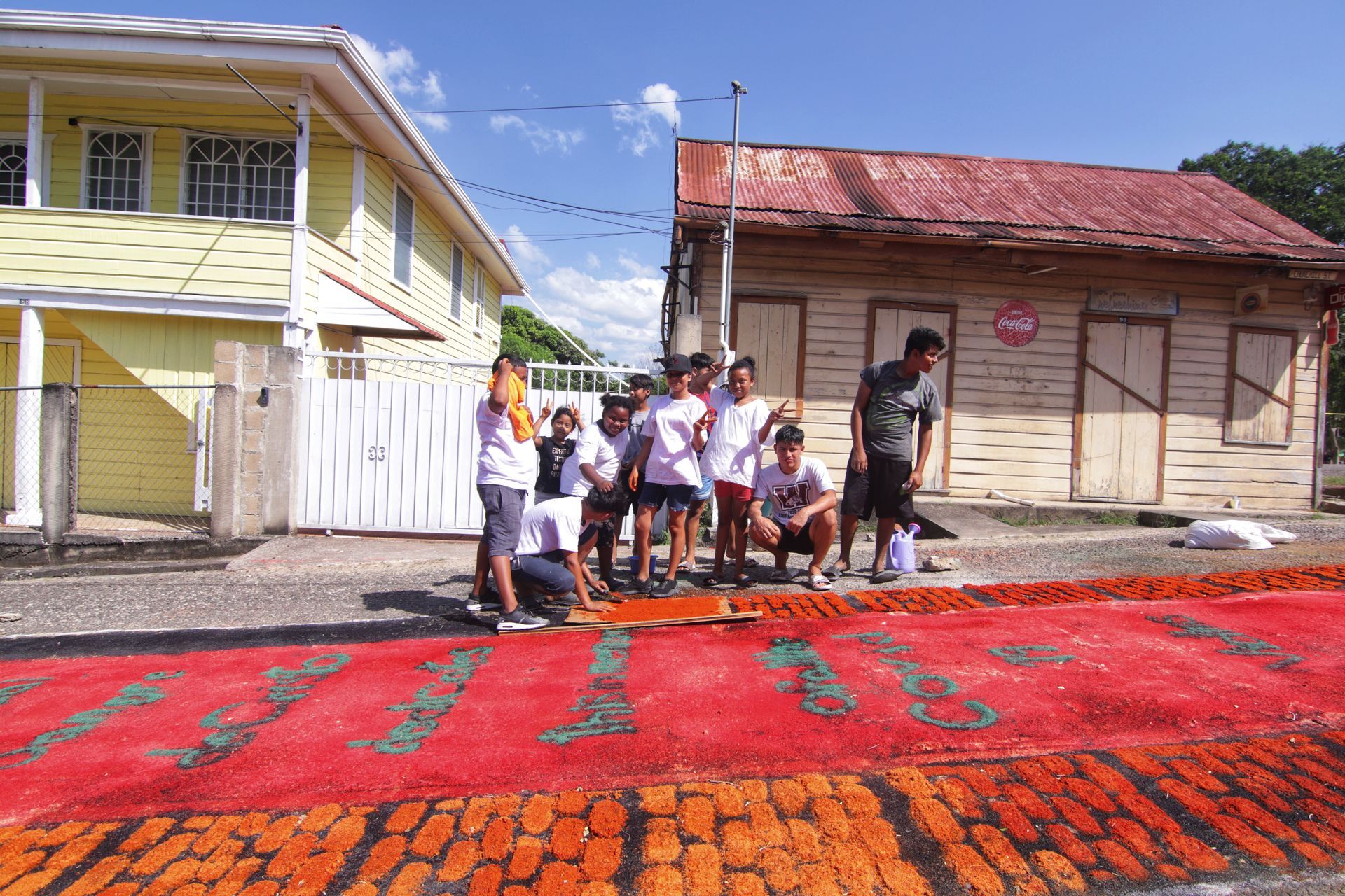 Group of San Ignacio Teens creating sawdust tapestries on the streets of San Ignacio. Photographed by Gian Witz