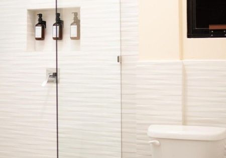 A bathroom with a toilet and a shower with a glass door.