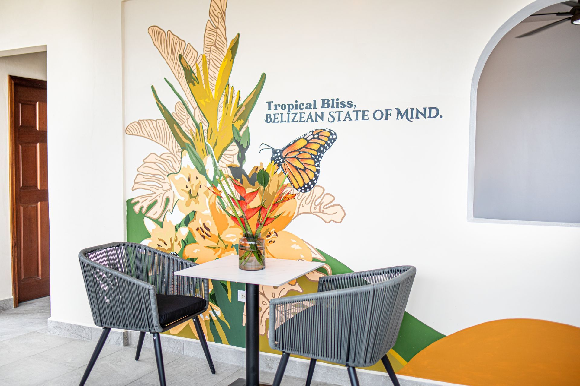 A room with a table and chairs and a mural on the wall.