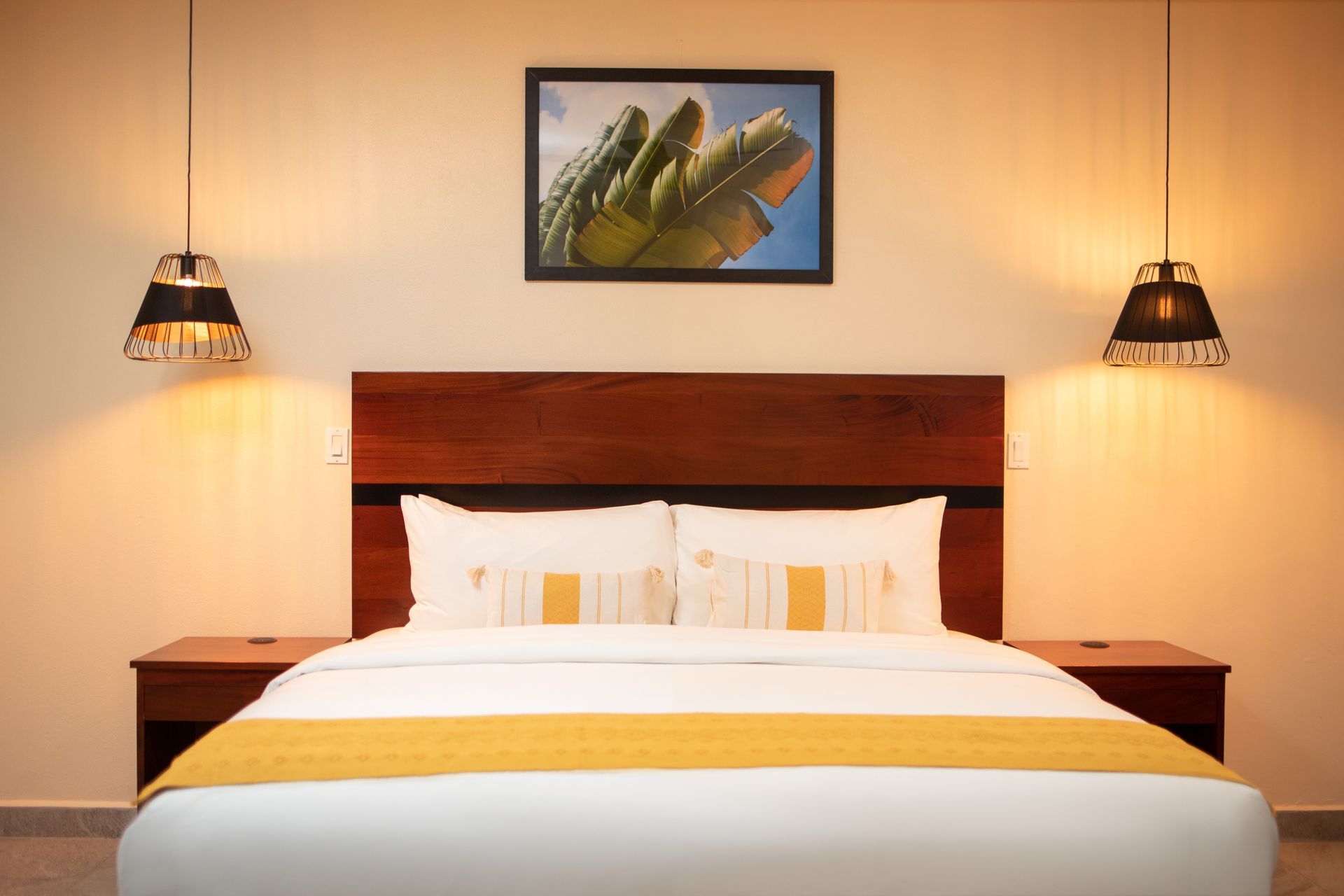A hotel room with a king size bed and a picture on the wall above it.