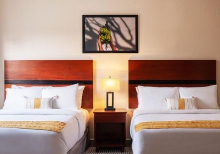 A hotel room with two beds and a lamp