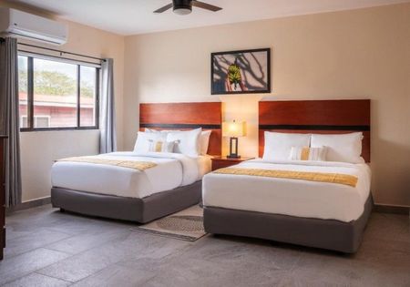 A hotel room with two beds and a ceiling fan