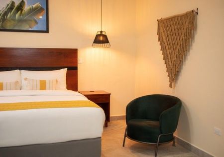A hotel room with a bed and a chair