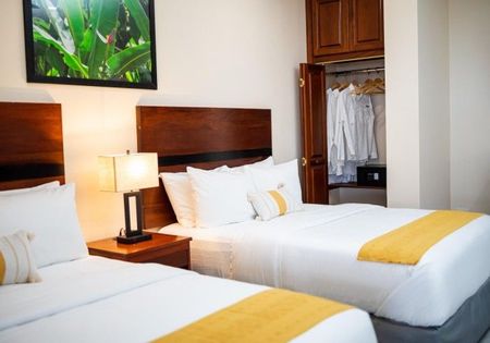 A hotel room with two beds and a picture on the wall