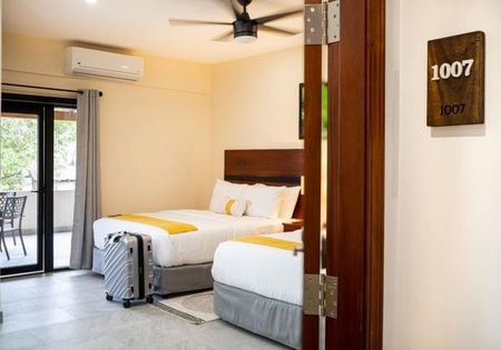 A hotel room with two beds and a sign that says 1007