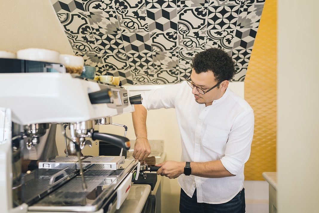 A man is working on a coffee machine in a kitchen.