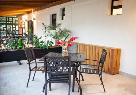 A table and chairs with a vase of flowers on it