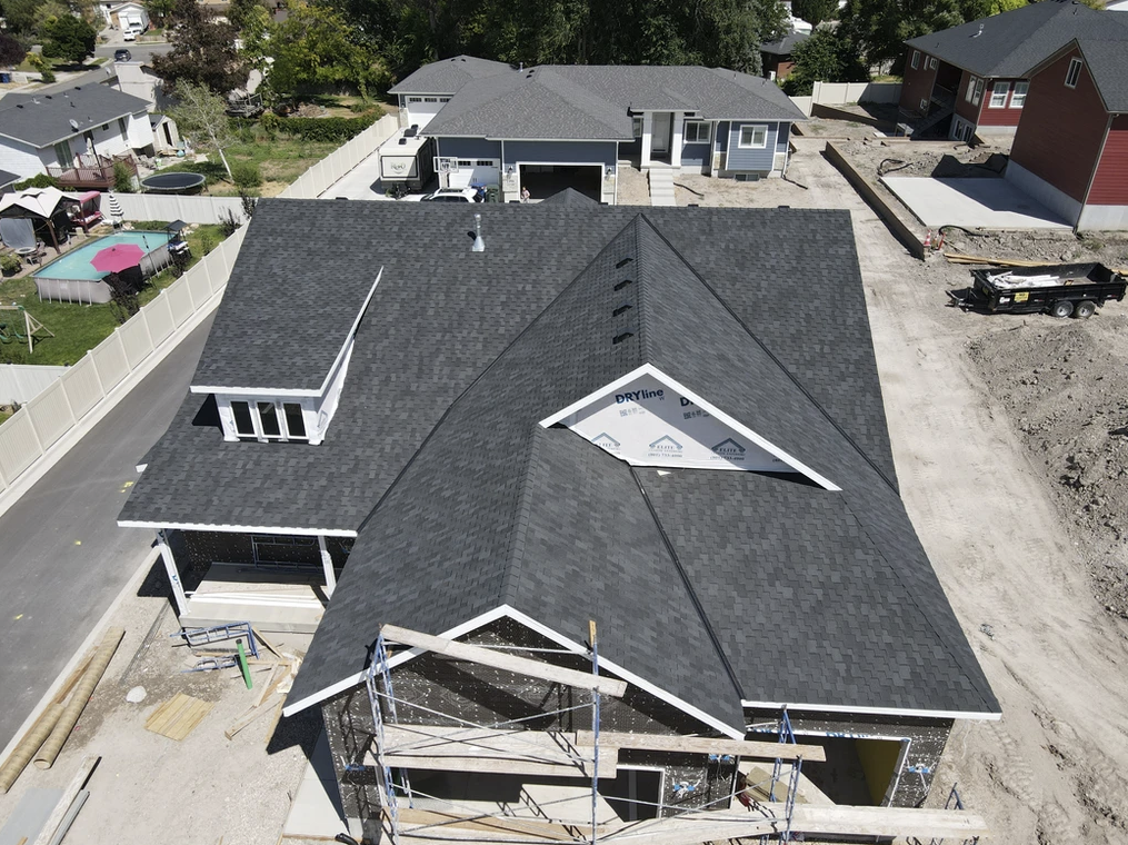 An aerial view of a house under construction with a black roof