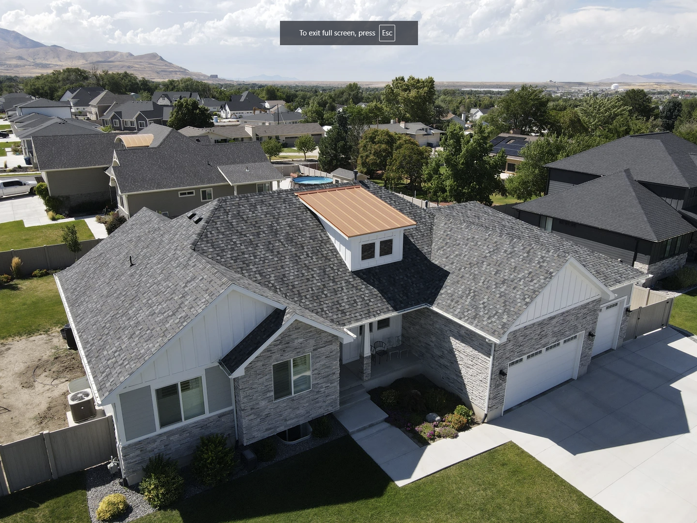 An aerial view of a house with a black roof