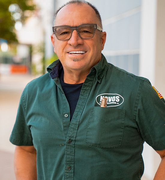 A man wearing glasses and a green shirt with the word vos on it