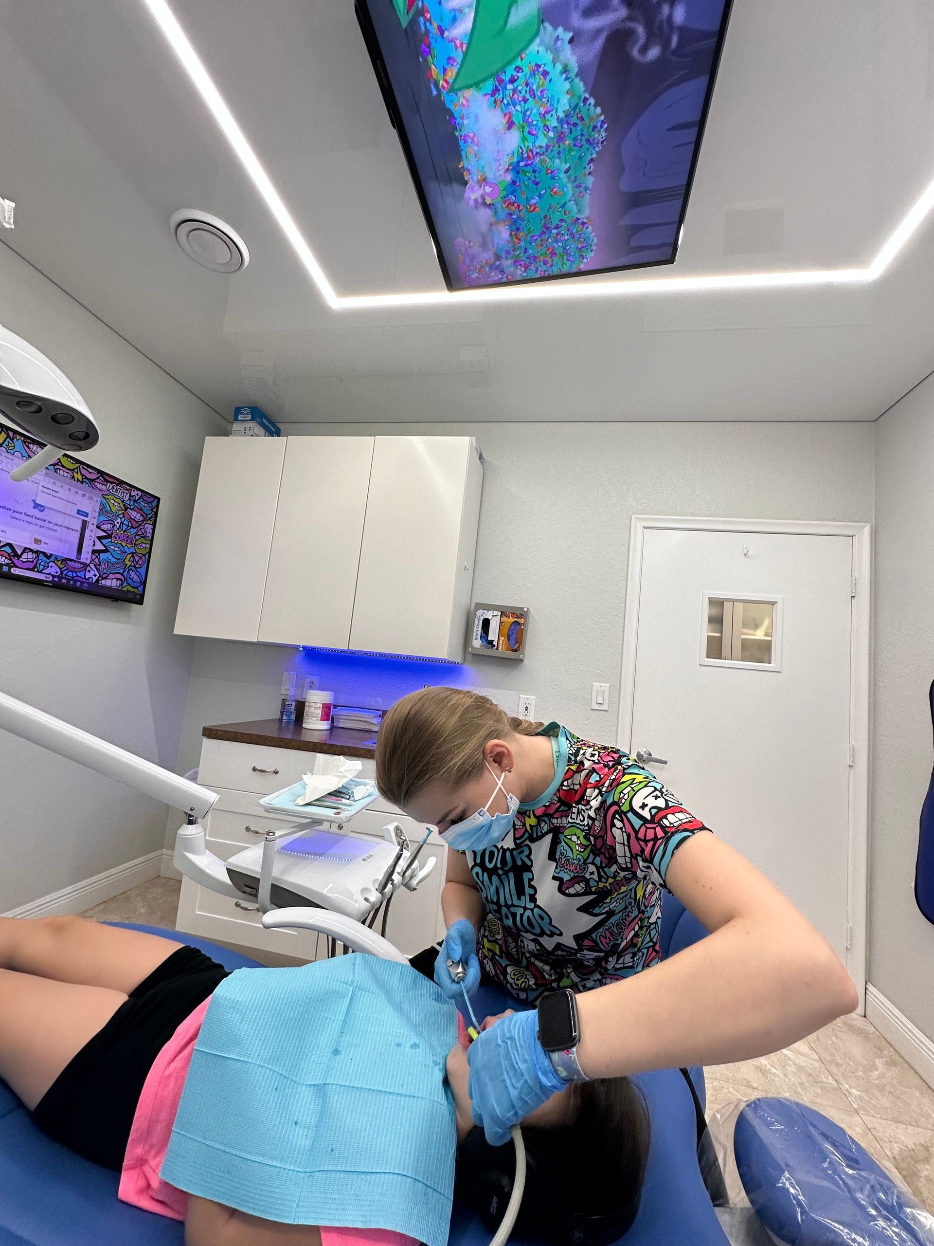 A woman wearing a mask is smiling in a dental chair