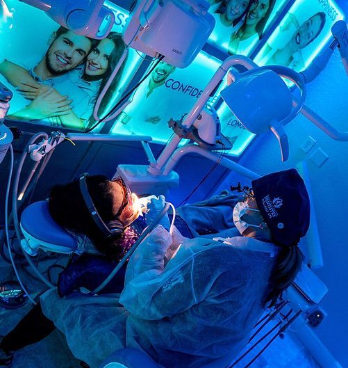 A dentist is working on a patient in a dental chair