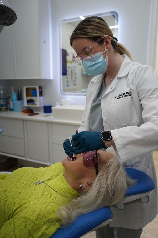A woman is getting her teeth examined by a dentist in a dental office.