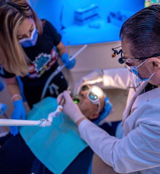 A dentist is examining a patient 's teeth in a dental office.