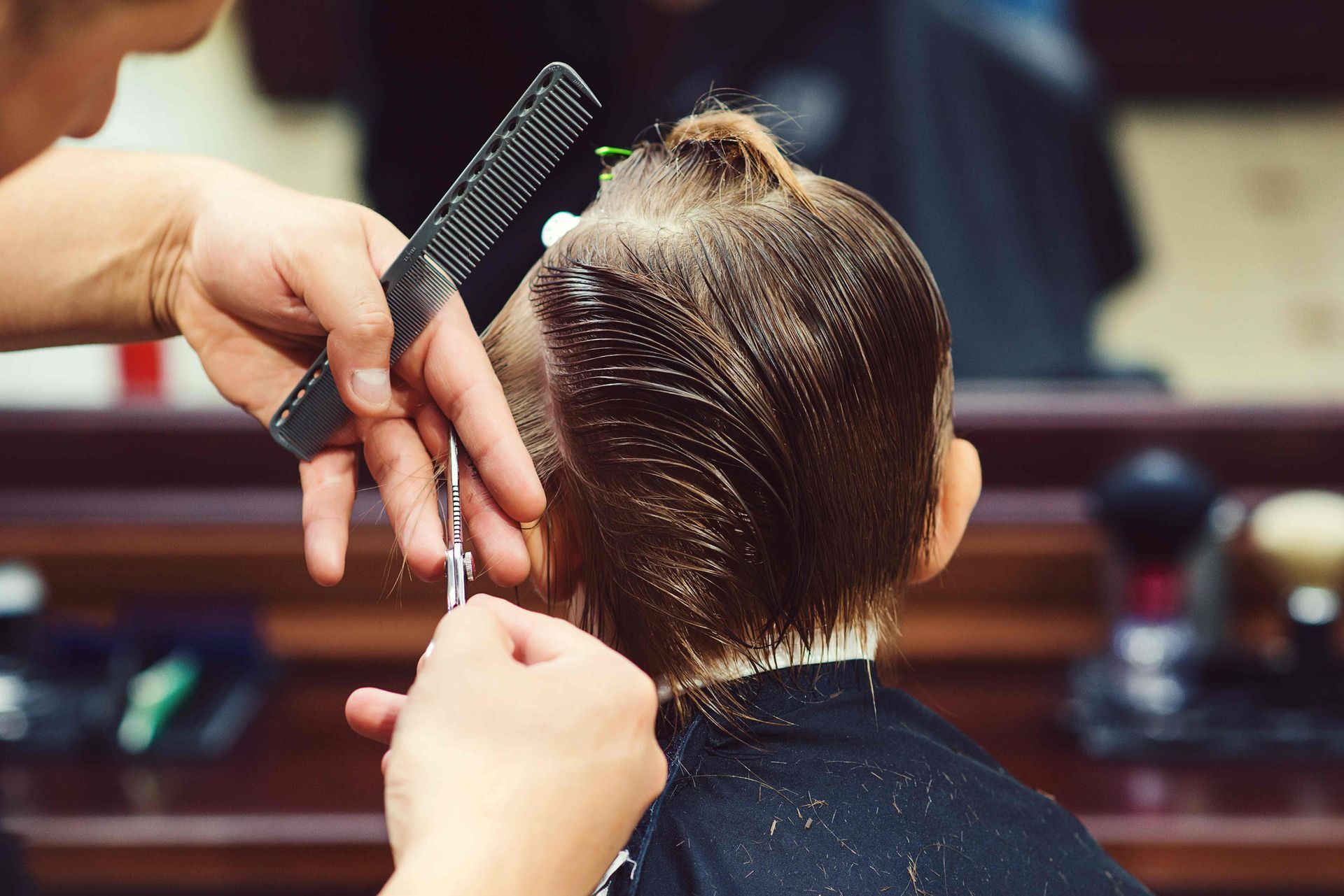 A kid getting a new haircut from a professional at Lux Hair Bar near Lexington, Kentucky (KY)