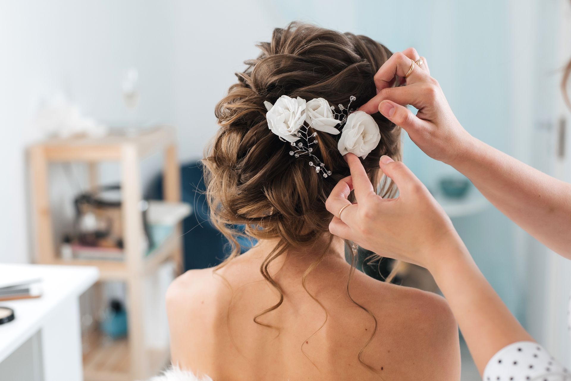Hair stylist placing accessories in a bridal hairstyle.
