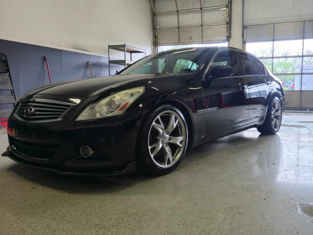 Black Infiniti G37 with a glossy exterior inside the Top Tier Detailing shop.