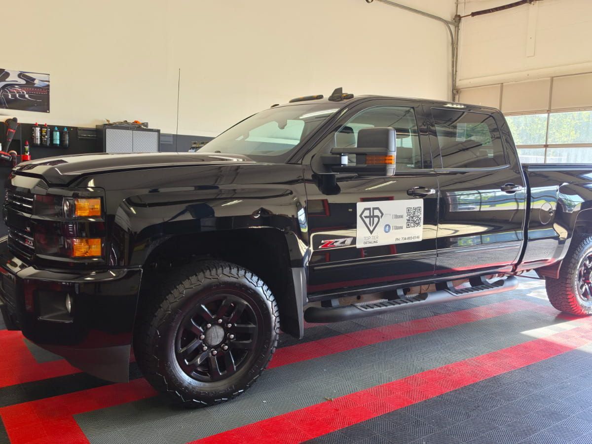 Black Chevrolet Silverado HD inside the Top Tier Detailing shop.