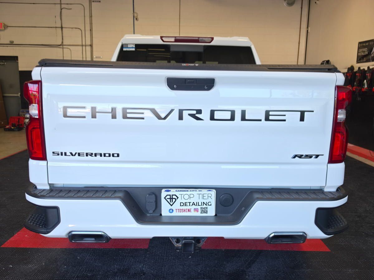 Rear view of a white Chevrolet Silverado RST inside the Top Tier Detailing shop.