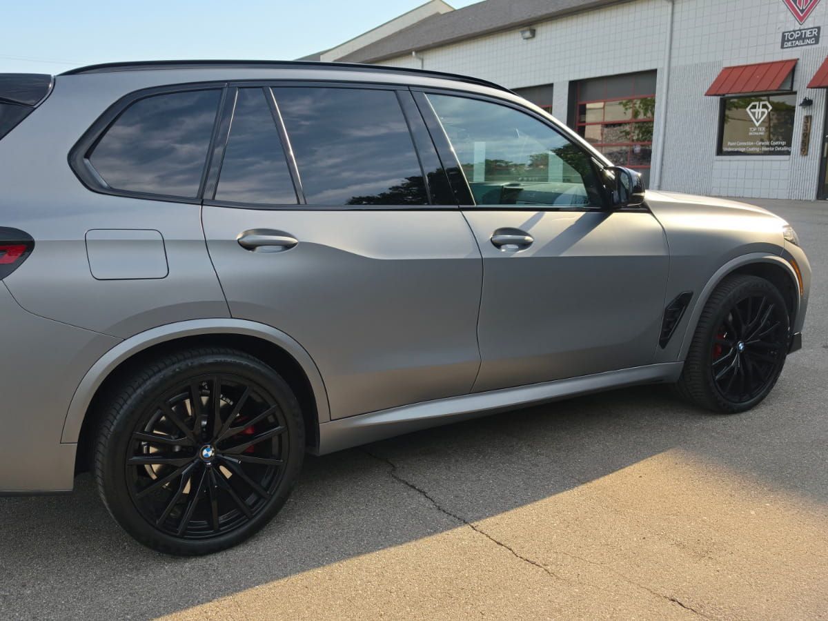 Gray BMW X5 parked outside Top Tier Detailing.