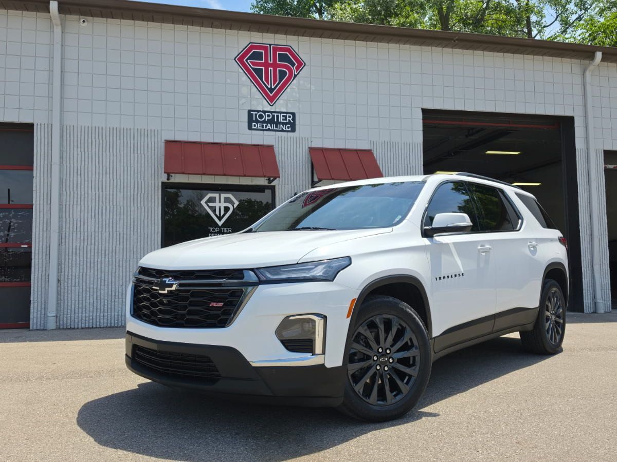 White Chevrolet Traverse RS parked outside Top Tier Detailing in Livonia.