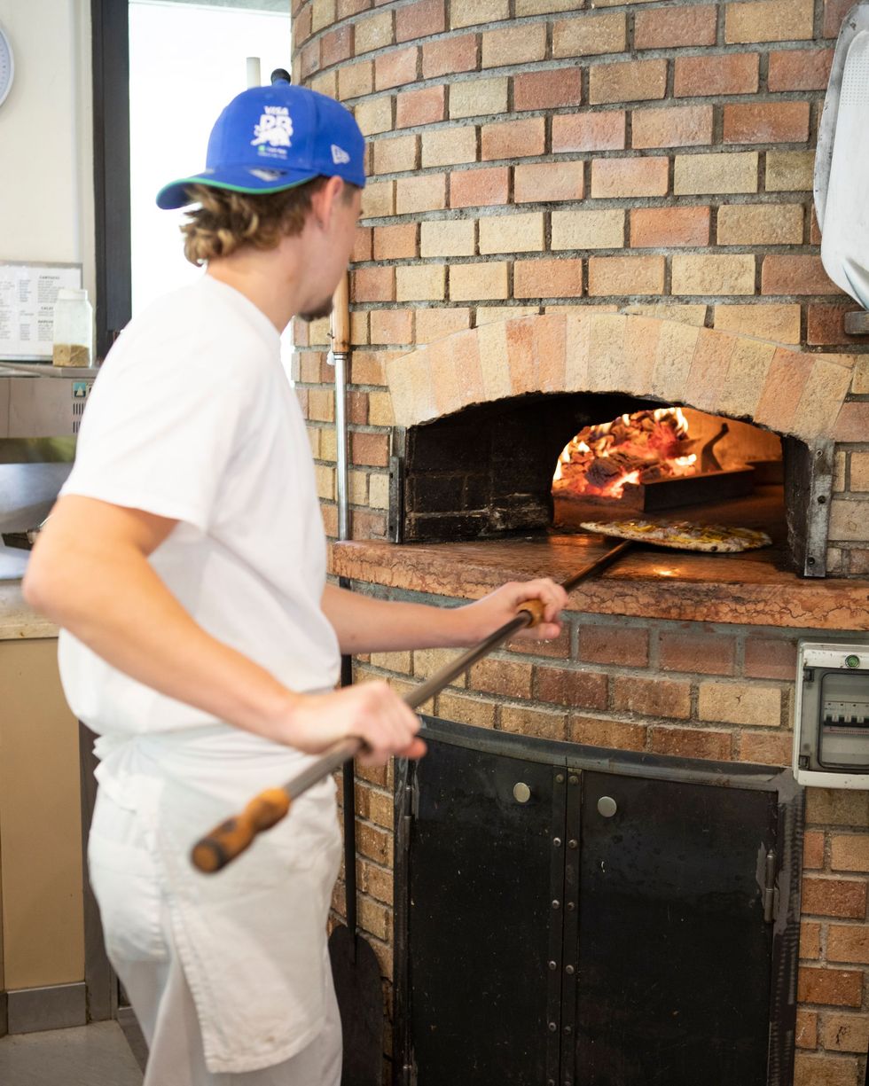 Preparazione della pizza nel forno a legna
