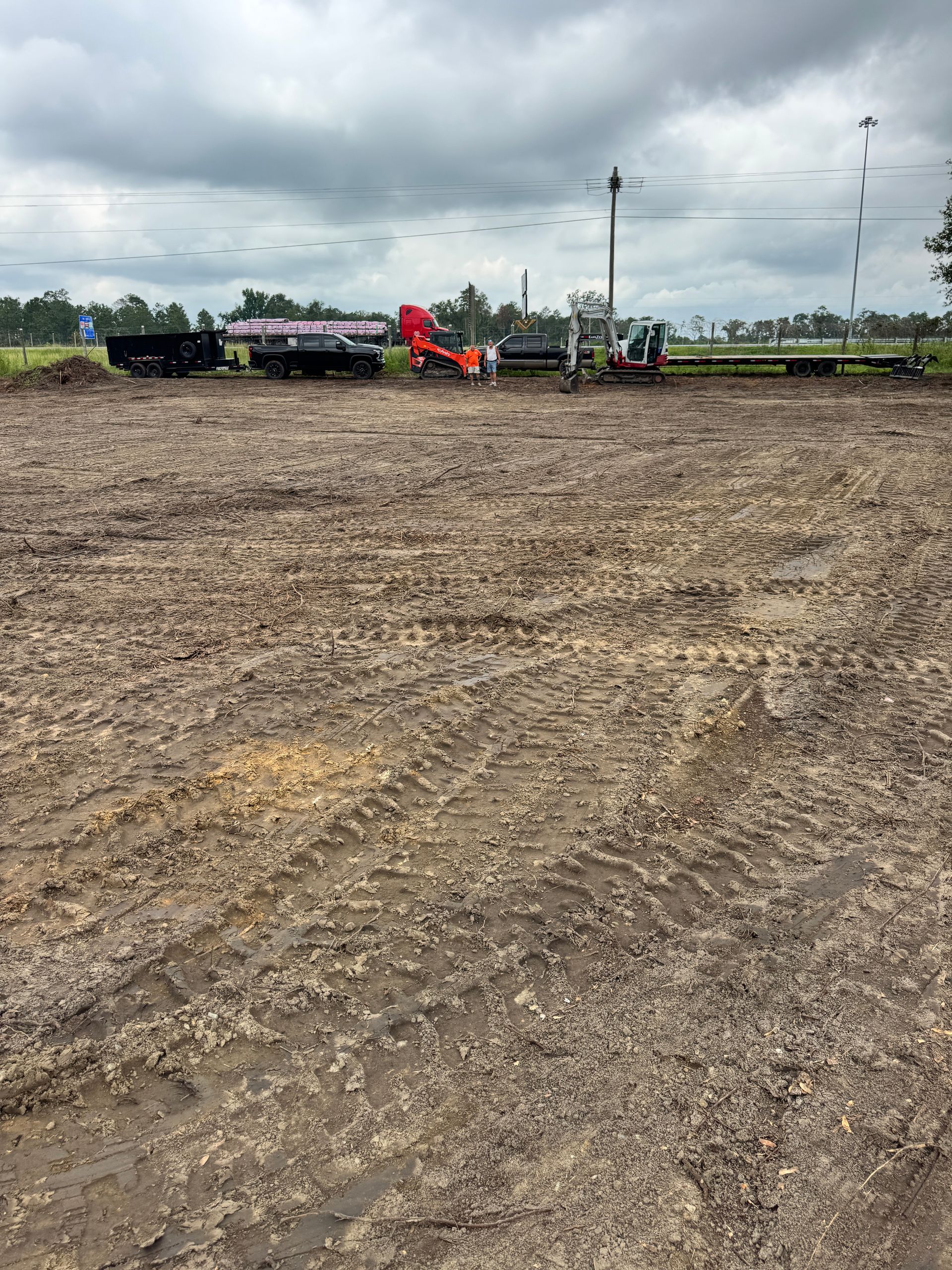 A large dirt field with a lot of trucks in it.