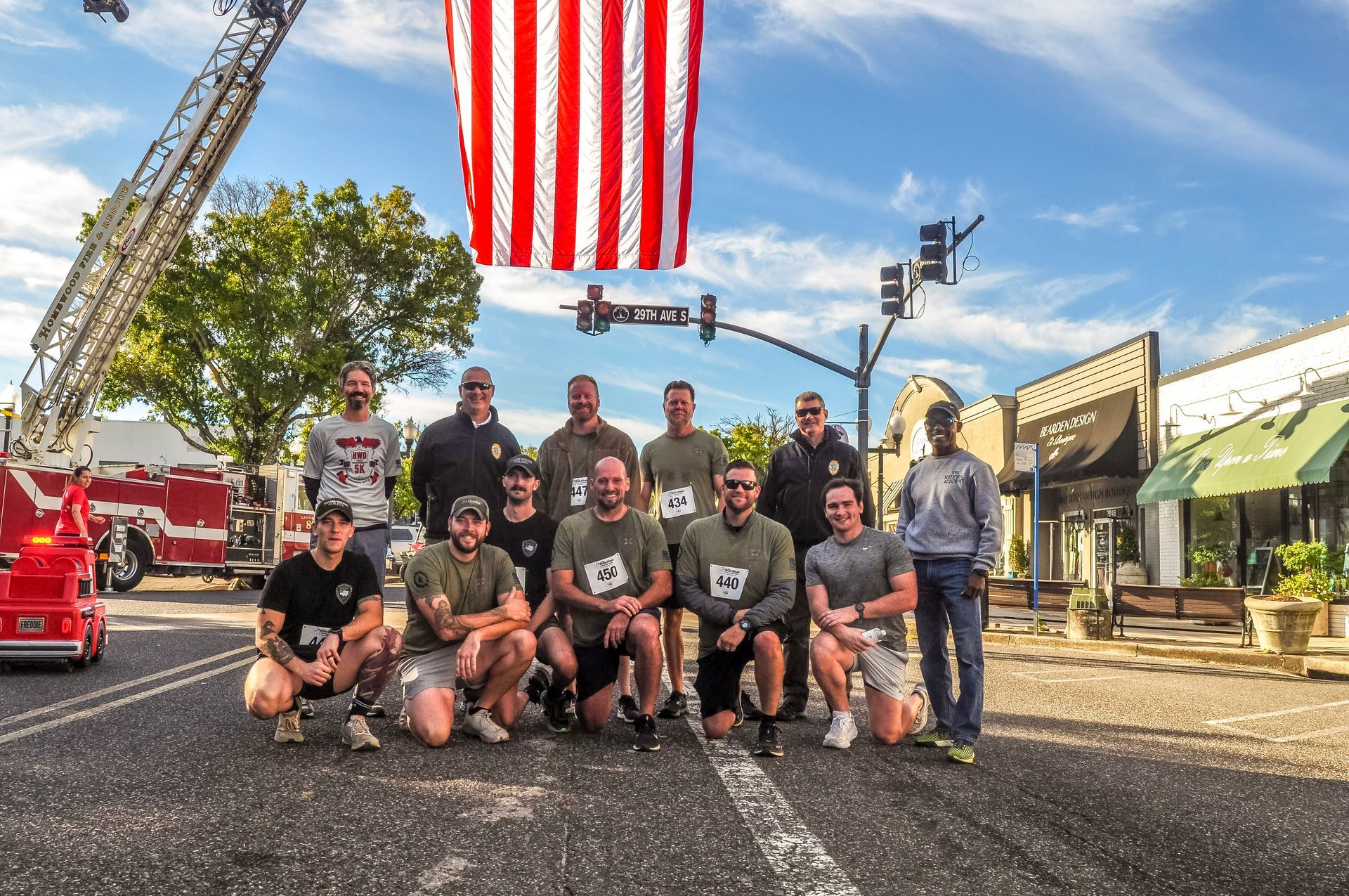 A group of men are posing for a picture in front of an american flag.