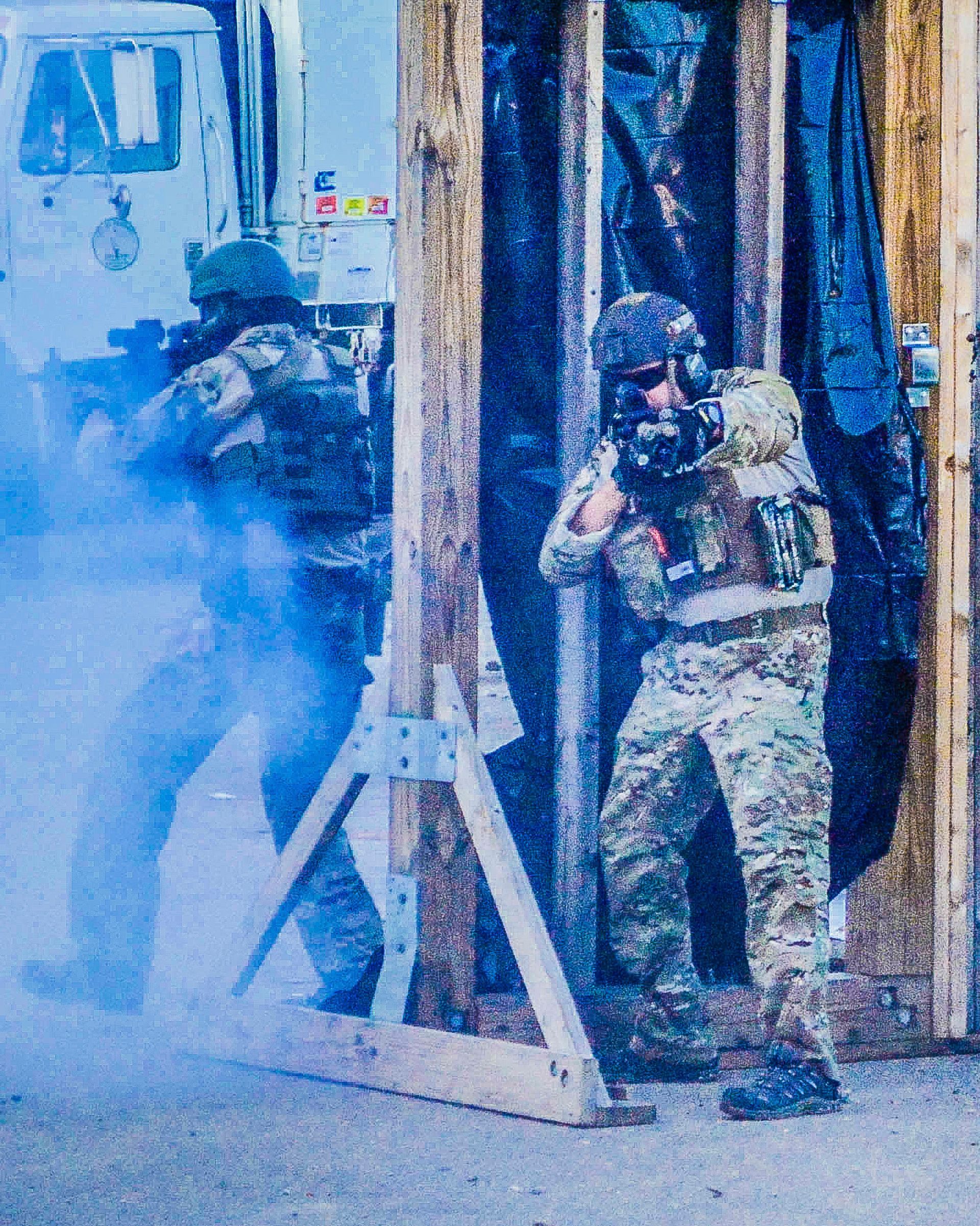 A group of soldiers are standing in a doorway with smoke coming out of it
