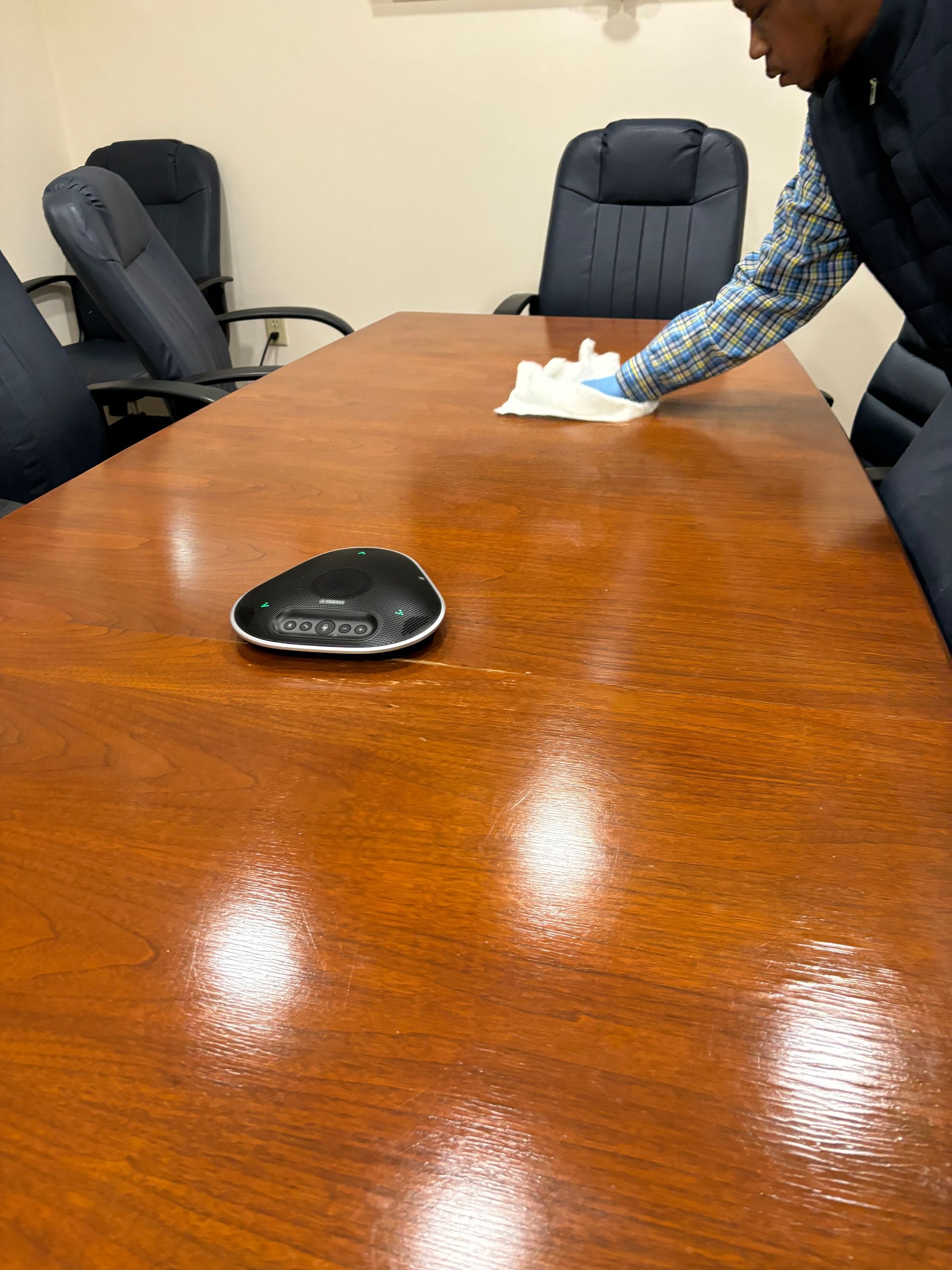 Three people in white protective hazmat suits and masks disinfect a room with handheld sprayers.