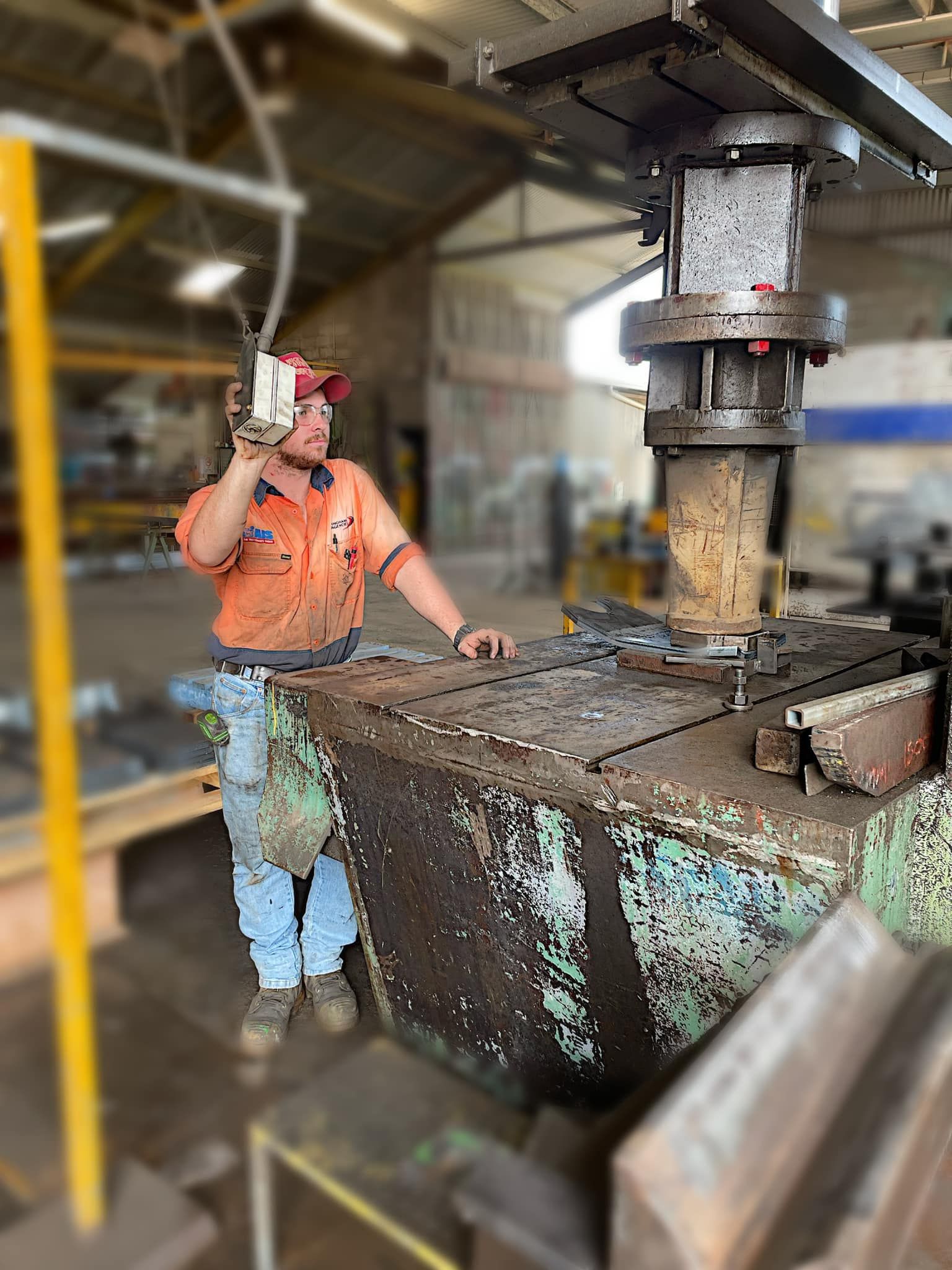 A Person Operates a Large Industrial Hydraulic Press — Ingham Agencies in Ingham, QLD